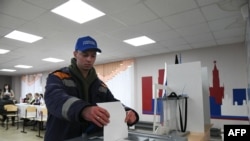 Україна та 55 країн ООН протестують проти проведення виборів президента Росії на територіях України, які окупує Росія. На фото люди голосують на президентських виборах у Росії у Донецькій області України. 15-го березня 2024 року. (Фото STRINGER / AFP)