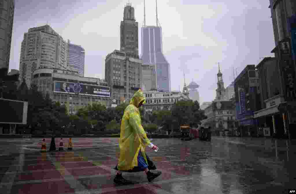 2018年8月25日,上海一条步行街,降雨时,街道清洁工带着一个空水瓶。