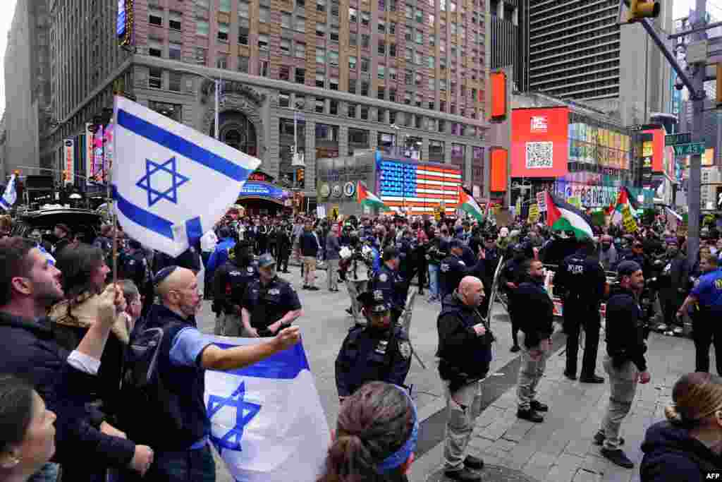 Polisi wa mjini New York wakiwatenganisha waandamanaji wanaoiunga mkono Israel (kushoto) kuwakaribia waandamanaji wanayoiunga mkono Palestina (kulia), kwenye uwanja wa Times Square Oktoba 8, 2023 baada ya wanamgambo wa Hamas kuishambulia Israel. 