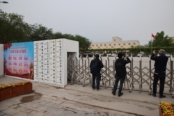Foreign journalists take photos and video outside a location that that was identified in early 2020 as a re-education facility by an Australian think tank.