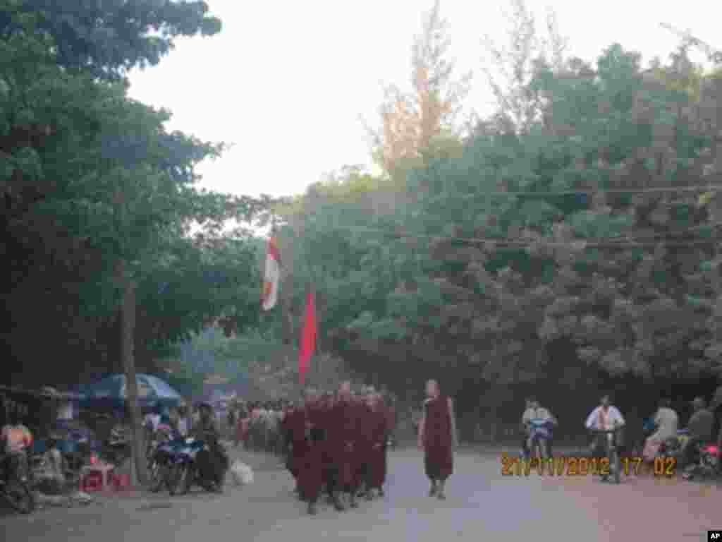 Petugas keamanan memegang bendera bertuliskan "Berhenti!" di gerbang yang menandai perbatasan antara kota Tamura dan Okuma di Okuma, prefektur Fukushima (1/4).