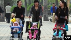 中国妇女推着婴儿车在北京公园里散步（2011年4月5日）