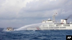资料照片：2023年12月10日，中国海警船向菲律宾供给船发射水炮。（美联社照片）