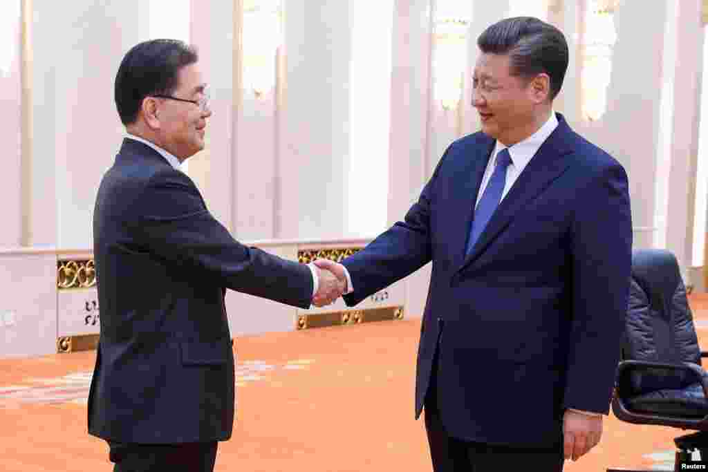 中国国家主席习近平(右)在北京人大会堂会见到访的韩国国家安保室长郑义溶(左)率领的韩国代表团。(2018年3月12日)