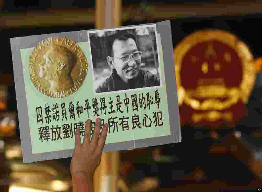 2010年10月8日,正在监牢服刑的《零八宪章》起草人、中国民主运动人士刘晓波获得诺贝尔和平奖的消息传来,香港民主活动人士前往中国驻香港联络办公室大楼前示威,敦促中国政府释放刘晓波,人们举着刘晓波及诺贝尔奖牌的照片。