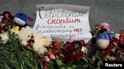 На фото - приклад антиамериканської та антиукраїнської пропаганди від Росії у Криму. Надпис на плакаті: "Севастополь горює. Америці та Зеленському немає пробаченя". REUTERS/Alexey Pavlishak
