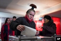 Жінка кидає свій виборчий бюлетень на виборчій дільниці під час сепаратистських виборів у Донецьку, 11 листопада 2018 року