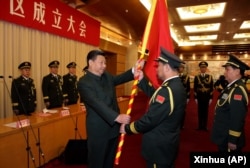 中国国家主席习近平（左前）在北京举行的中国人民解放军战区成立大会上向五大战区授予军旗。（2016年2月1日）
