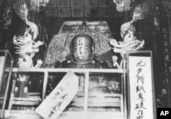 历史照片：红卫兵给杭州灵隐寺的佛像贴上“打碎旧世界”等标语。(1966年8月27日)