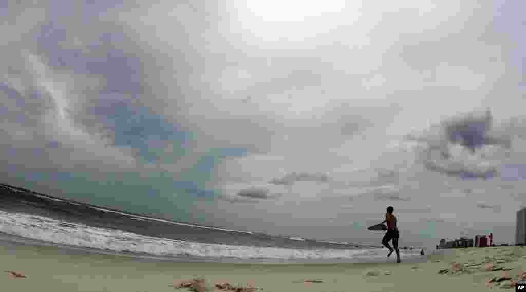 Một thiếu niên ở Orange Beach, tiểu bang Alabama, chuẩn bị trợt sóng trước khi bão tới. 27/8/2012.