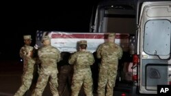 在德拉瓦州多佛空军基地，空军殡仪队成员把枪击案死难者、海军见习航空兵卡梅伦·斯科特·沃尔特斯的灵柩抬入车内。(2019年12月8日)