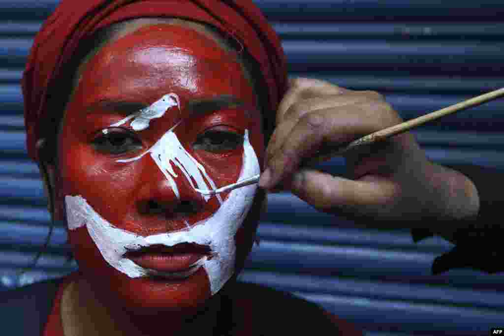 A supporter of a faction of the ruling Nepal Communist Party (NCP) gets her face painted before taking part in a "victory" rally after Supreme Court ruling to overturn the prime minister's decision to dissolve parliament, in Kathmandu.