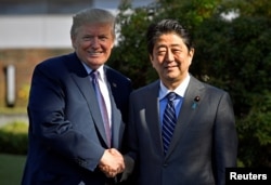 美国总统川普与日本首相安倍晋三在霞关乡村俱乐部前握手。（2017年11月5日）