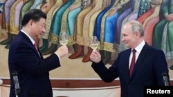 资料照片：俄罗斯总统普京与中国国家主席习近平在克里姆林宫的招待会上举杯致意。: (2023年3月21日)