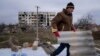 Місцевий житель допомагає сусіду лагодити зруйнований будинок, Архангельське, Херсоншина, 5 грудня 2022. (AP Photo/Evgeniy Maloletka)