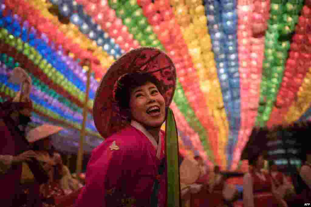 A reveler dances beneath lanterns at the Jogye buddhist temple following a lantern parade as part of a 'Lotus Lantern Festival' celebrating the upcoming Buddha's birthday, in Seoul, South Korea, May 12, 2018.