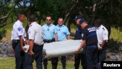 法国航空专家与警方抬起在一个法属印度洋岛屿上发现的一块飞机残骸 （2015年7月29日）