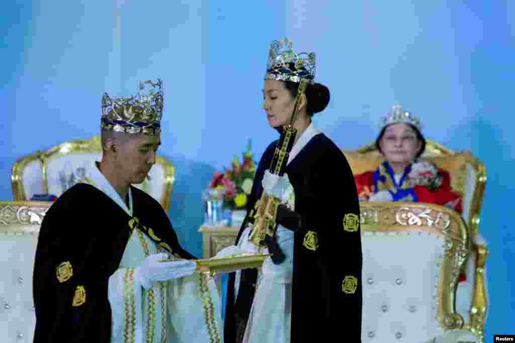 Reverend Hyung Jin Moon, the church's pastor and the son of the late Sun Myung Moon, attends a ceremony while people with their AR-15-style rifles in their cases watch the event at the Sanctuary Church in Newfoundland, Pennsylvania, Feb. 28, 2018.
