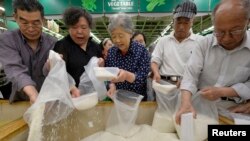 资料照：山西省太原市一家超市里的顾客在买大米。（2013年5月22日）