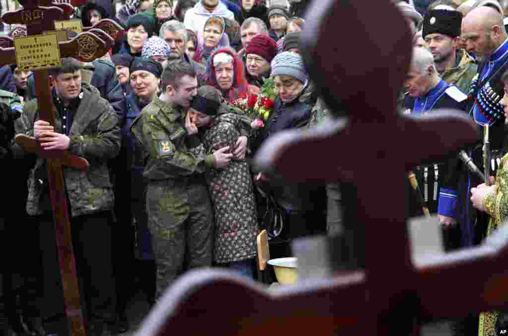 Family and friends of victims of the deadly attack on churchgoers in Russia's predominantly Muslim Dagestan region, attend a funeral service in Kizlyar, Russia.
