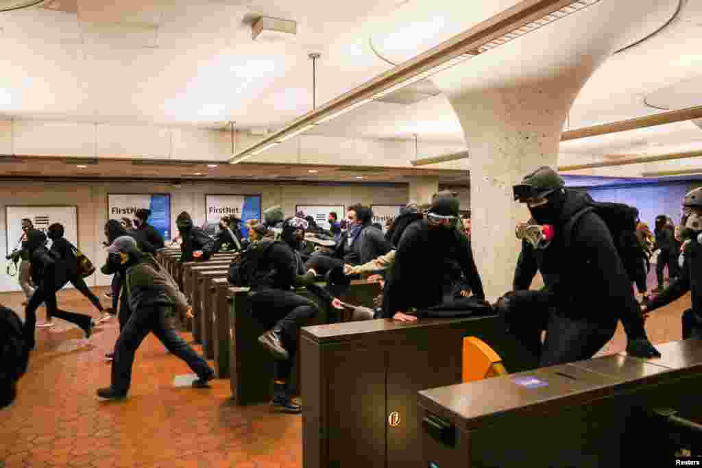 Protesters jump over the turnstiles at the Gallery Place metro station during a protest following the fatal police shooting of 20-year-old Black man Daunte Wright in Minnesota, in Washington, D.C., April 12, 2021.