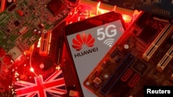 资料照：在一块电脑母版上的英国国旗和有着华为与5G网络标识的手机。（路透社2020年1月29日）
