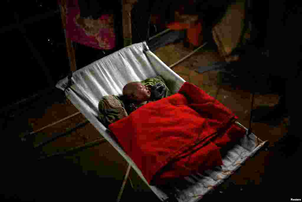 A Rohingya refugee baby girl sleeps inside her family's temporary shelter at the Balukhali refugee camp near Cox's Bazar, Bangladesh.