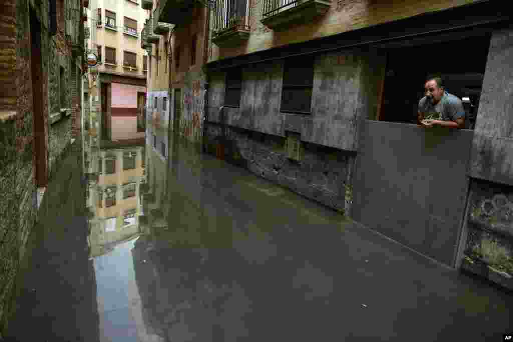 A man looks down from the door of a house affected by water from the Ebro River, in Tudela, northern Spain. Heavy rain has lead to flooding in northern Spain over the past few days, especially in Navarra provinces and Aragon.