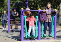 资料照：北京天坛公园里的老年人和他们的独生子女的孙辈在锻炼身体。（2011年10月25日）