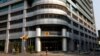 FILE - A woman walks past the head office of Angola's state oil company Sonangol in the capital Luanda, Angola, Aug. 26, 2012. 