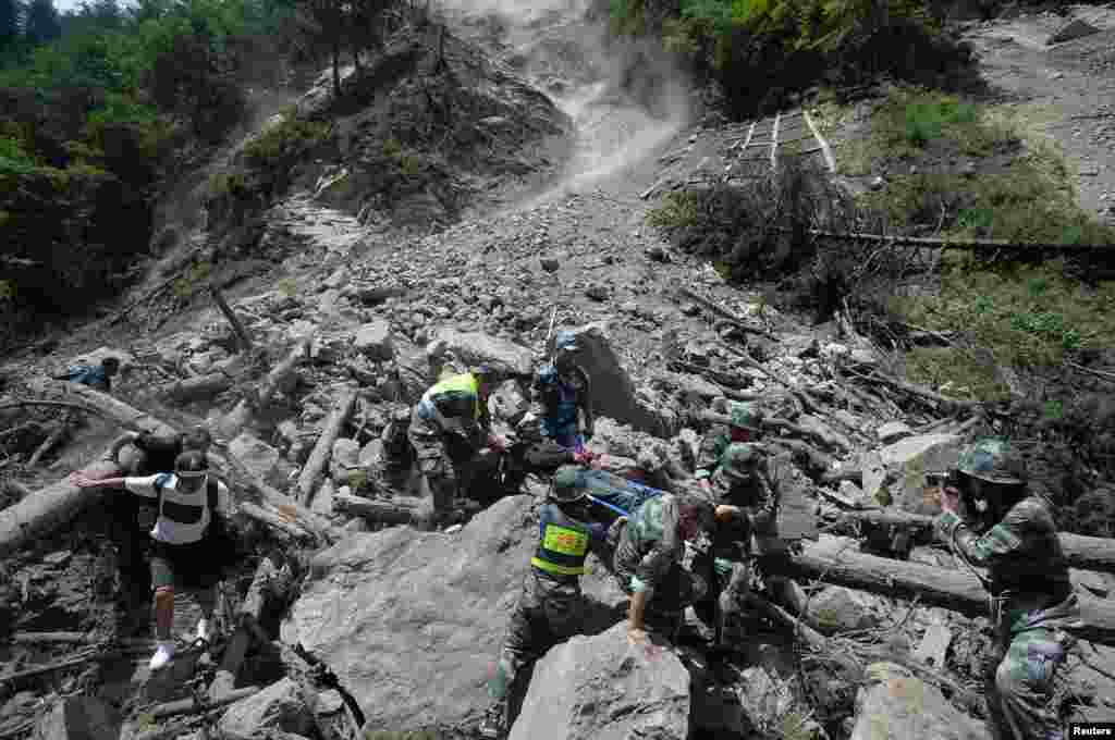 中国武警在四川阿坝州九寨沟县附近发生强烈地震后抢救幸存者(2017年8月9日)。美国地质调查局测量的震级为6.5级,中国地震中心说,震级为7级。整个地区毁损房屋10万多间,电力中断。这次地震距2008年重创该地区的八级地震所在地很近,八万七千多人在那次地震中死亡或者失踪。与此同时,当局正在应对新疆的强震,美国地质调查局测量的震级为6.3级。新华社说,至少三名村民在住房倒塌时受伤。