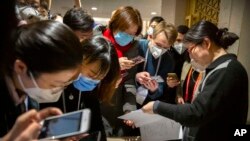 记者们在北京国务院新闻办公室阅读中国政府声明。（2020年1月26日）
