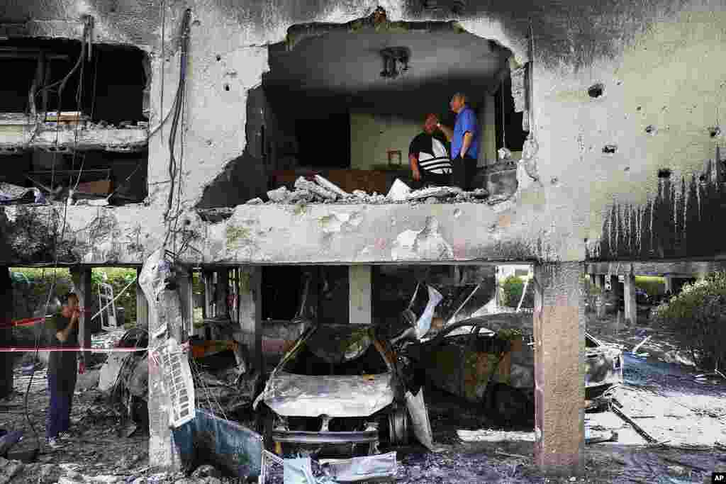 Members of Sror family inspect the damage to their apartment after it was hit by a rocket fired from the Gaza Strip overnight in Petah Tikva, central Israel.