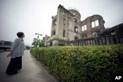 1945年原子弹爆炸的幸存者公江三原看着广岛原子弹和平纪念圆塔。（2015年3月7日）