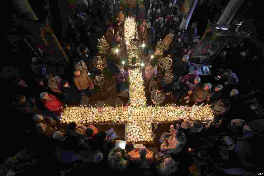 Worshippers gather around a cross during Mass for the 'sanctification of honey' at the Presentation of the Blessed Virgin church in the town of Blagoevgrad, some 100 km (62 miles) south of the Bulgarian capital of Sofia.