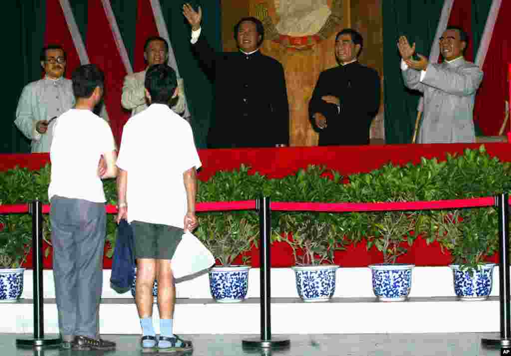 在北京举办的中共建党纪念日的展览中,有人观看中共领袖塑像。左起:任弼时,刘少奇,毛泽东,周恩来和朱德(2004年6月29日)