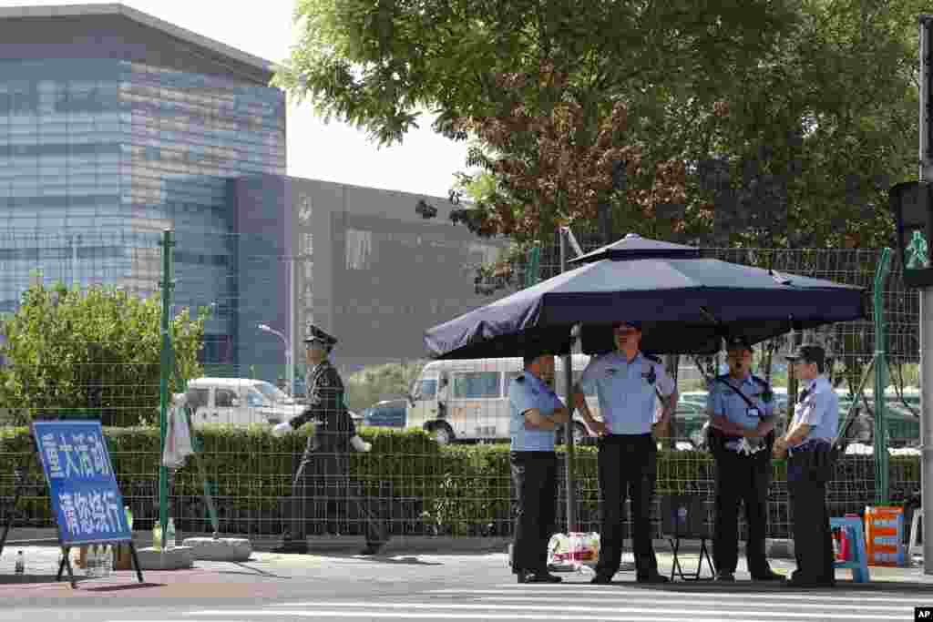 在北京的 “一带一路”国际合作高峰论坛举行期间,场外戒备森严,一个武警走过一个警察哨所(2017年5月14日)。 北京及各地加大维稳力度,展开严密监控维权和民主人士,以及阻截赴京访民的行动。