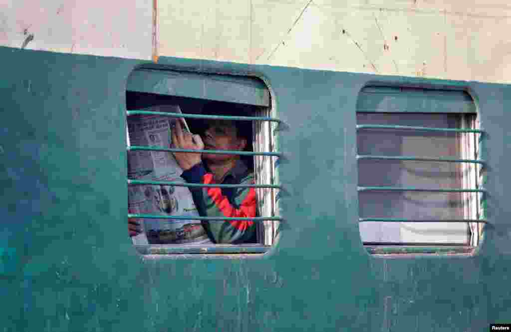 A man reads a newspaper on an intercity train in New Delhi, India.