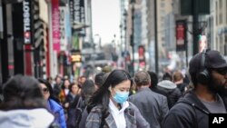 曼哈顿中城街道上一个戴口罩的妇女（3月3号）。