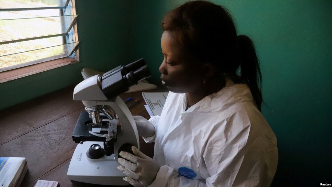 FILE - A laboratory worker uses a microscope at the health center in the commune of Wangata during a vaccination campaign against the outbreak of Ebola, in Mbandaka, Democratic Republic of the Congo, May 23, 2018. 