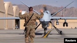 2016年3月9日一名美军空军士兵在坎大哈机场导引一架美国空军MQ-9“收割者”无人机滑向跑道