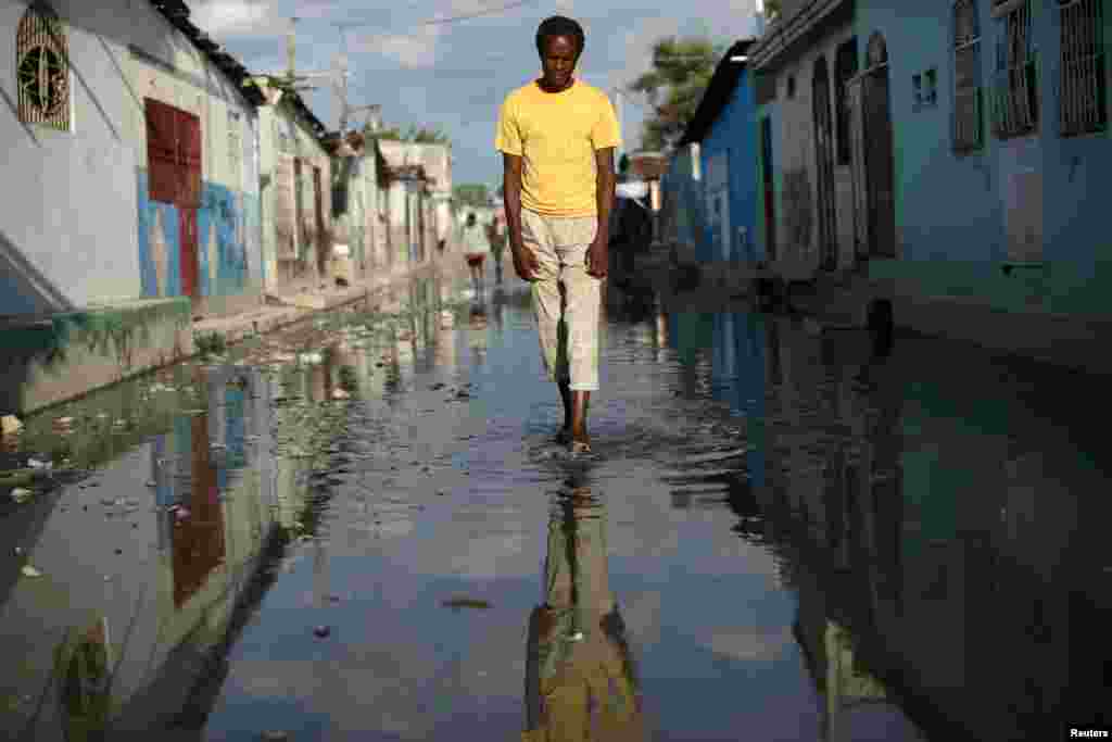 A man walks along a flooded street in Cite Soleil, Port-au-Prince, Haiti.