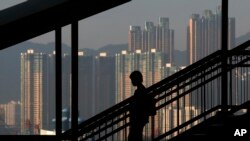 一位女士沿步道而下，背景是香港的摩天大楼。（资料照）