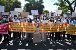 人们聚集在中国驻仰光大使馆外抗议军人政变并要求释放昂山素季。（2021年2月11日）