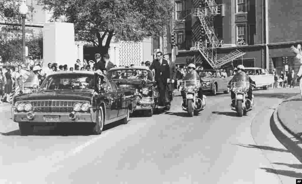Hình ảnh cho thấy dường như Tổng thống Kennedy giơ tay lên đầu chỉ vài giây sau khi ông bị bắn trong lúc đoàn xe chạy ngang tòa nhà Texas School Book Depository tại Dallas, ngày 22/11/1963