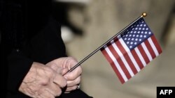 Жінка тримає прапорець США під час церемонії відзначення Дня ветеранів на Арлінгтонському національному цвинтарі у штаті Вірджинія