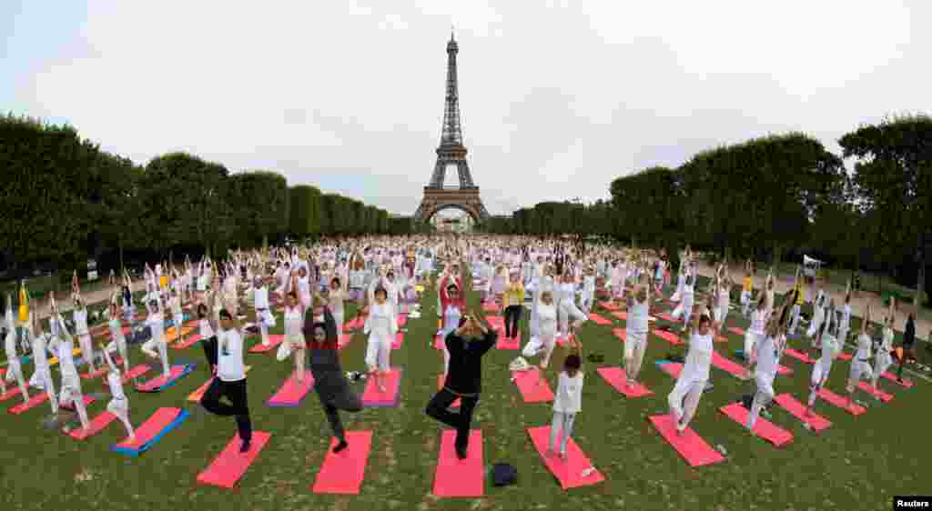 People gather for an open-air yoga session near the Eiffel tower in Paris, France.