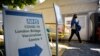 FILE - Signs are posted at the entrance to the London Bridge Vaccination Centre as people leave after receiving doses of a COVID-19 vaccine in London, Britain, Aug. 9, 2021. 