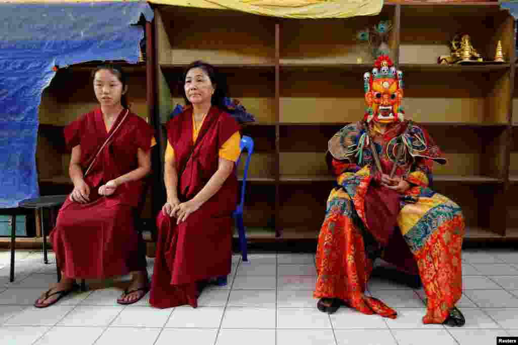 A Tibetan Buddhist monk wearing traditional costume waits to perform ritual dance on Vesak Day at the Enlightened Heart Tibetan Buddhist temple in Ipoh, Malaysia.
