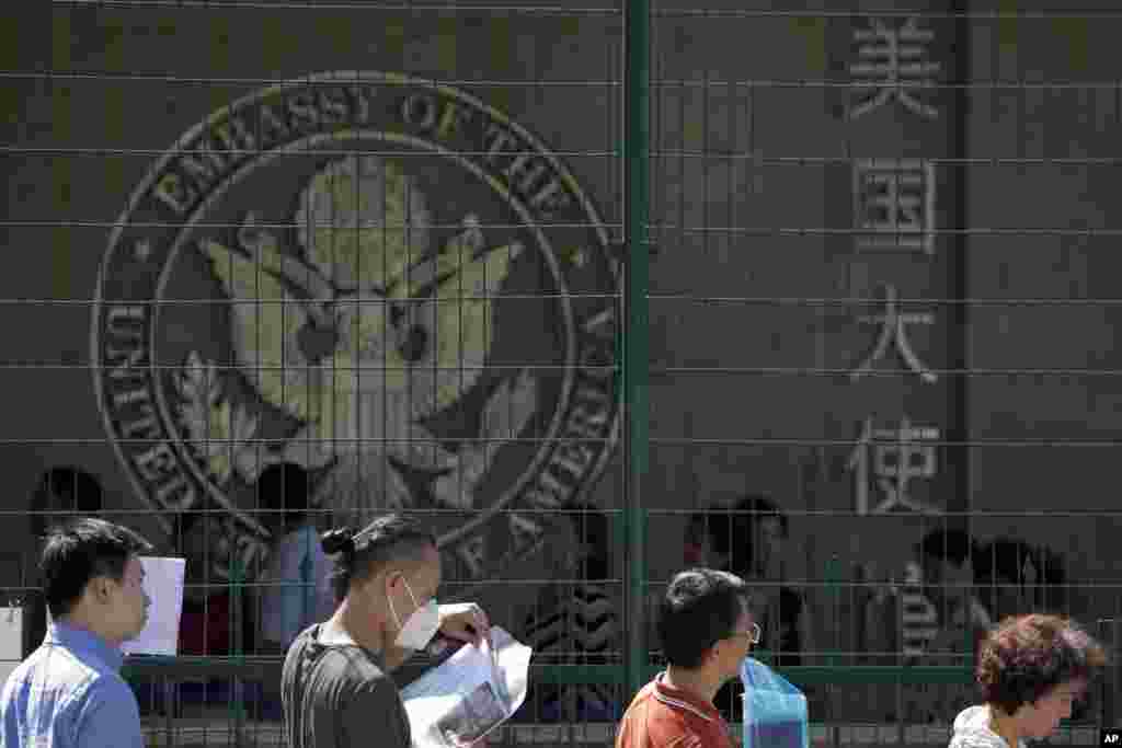 人们在中国北京的美国大使馆外排队等候(2018年7月26日)。美联社在图片说明中援引美国国土安全部的消息说,70多万应该在2016年10月到2017年9月离境的外国人在签证到期后滞留美国。美联社电讯说,在此期间签证到期不离开美国的70万零1900人只包括乘飞机或船只抵达美国的人,不包括从陆地进入美国的人,因此签证逾期滞留的人数实际更多。这些滞留美国的人中外国学生和访问学者占4.2%。据估计,目前非法居留美国的1100万人中有40%是签证到期后滞留不走。